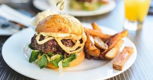 A gourmet cheeseburger with potato wedges served at a local restaurant in Sheboygan, WI